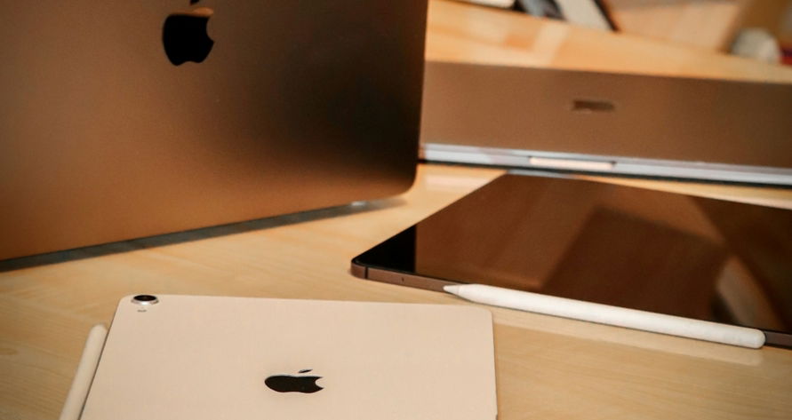 silver macbook on brown wooden desk